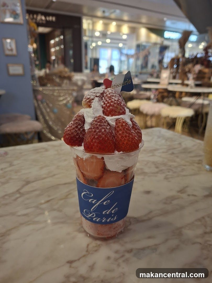 Strawberry parfait with whipped cream and a pastry flag