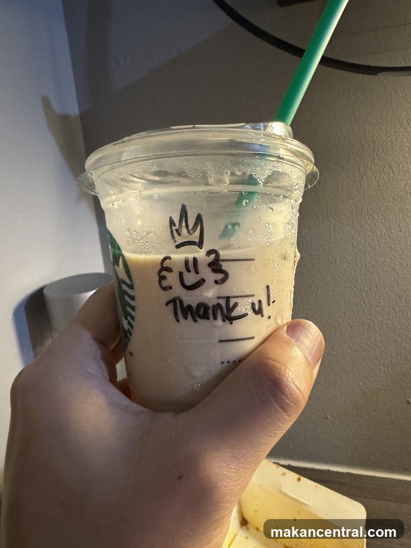 Hand holding a Starbucks drink with a handwritten message