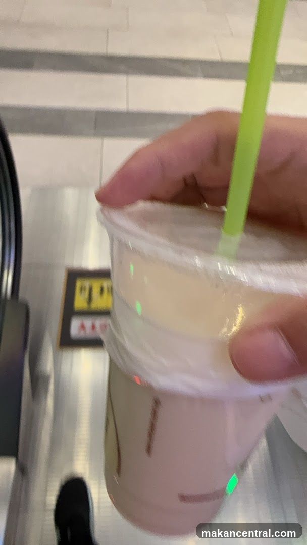 Hand holding a drink with a straw