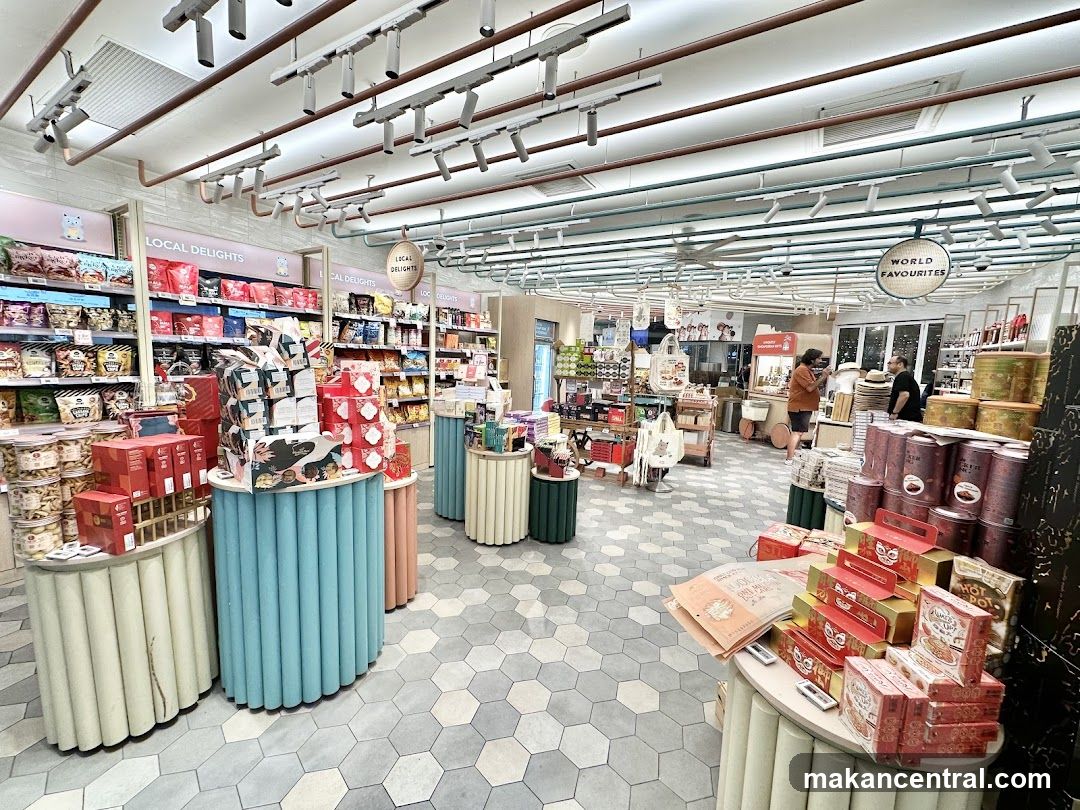 Interior of a well-lit store with shelves stocked with various food items and gift boxes.