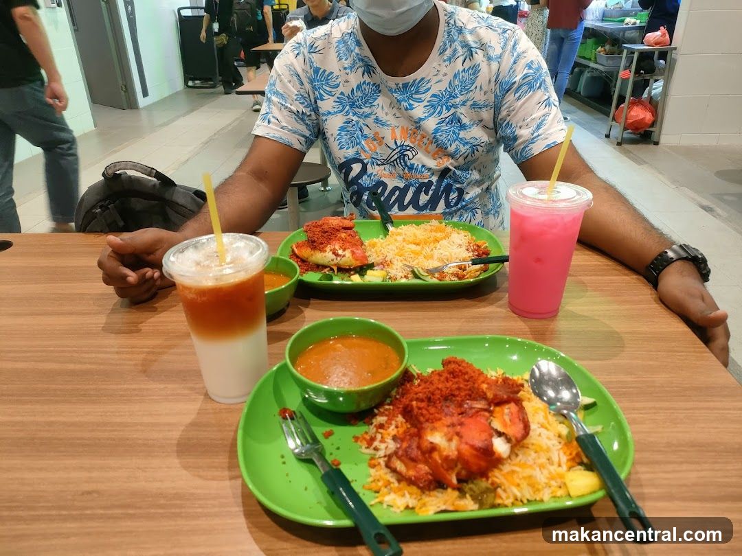 Two plates of biryani with chicken and drinks