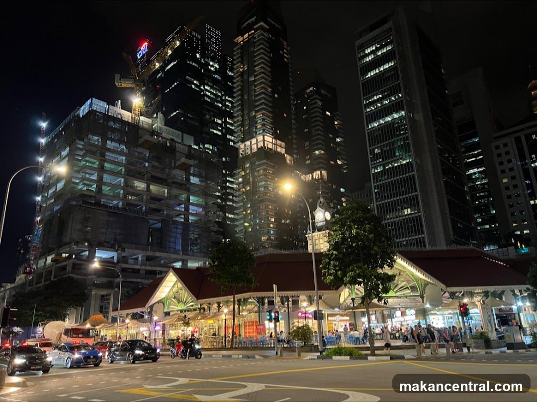 Night view of a busy street with a market and skyscrapers
