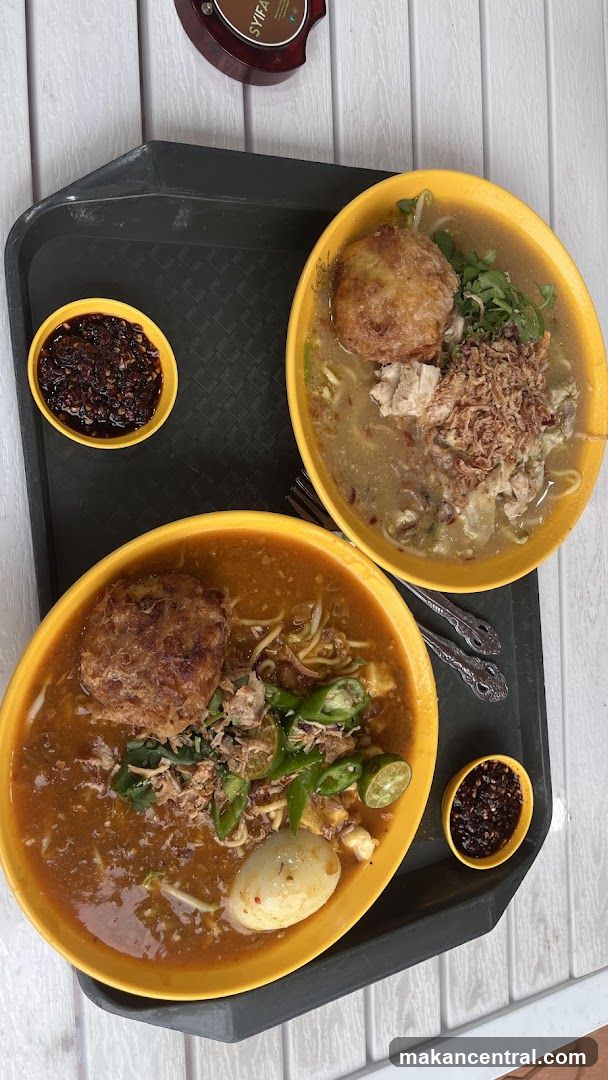 Two bowls of noodles with fried egg and chili paste