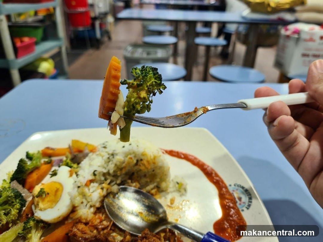 Close-up of a fork with vegetables over a plate of food