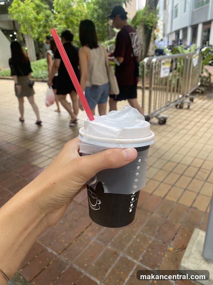 Person holding a coffee cup with a straw