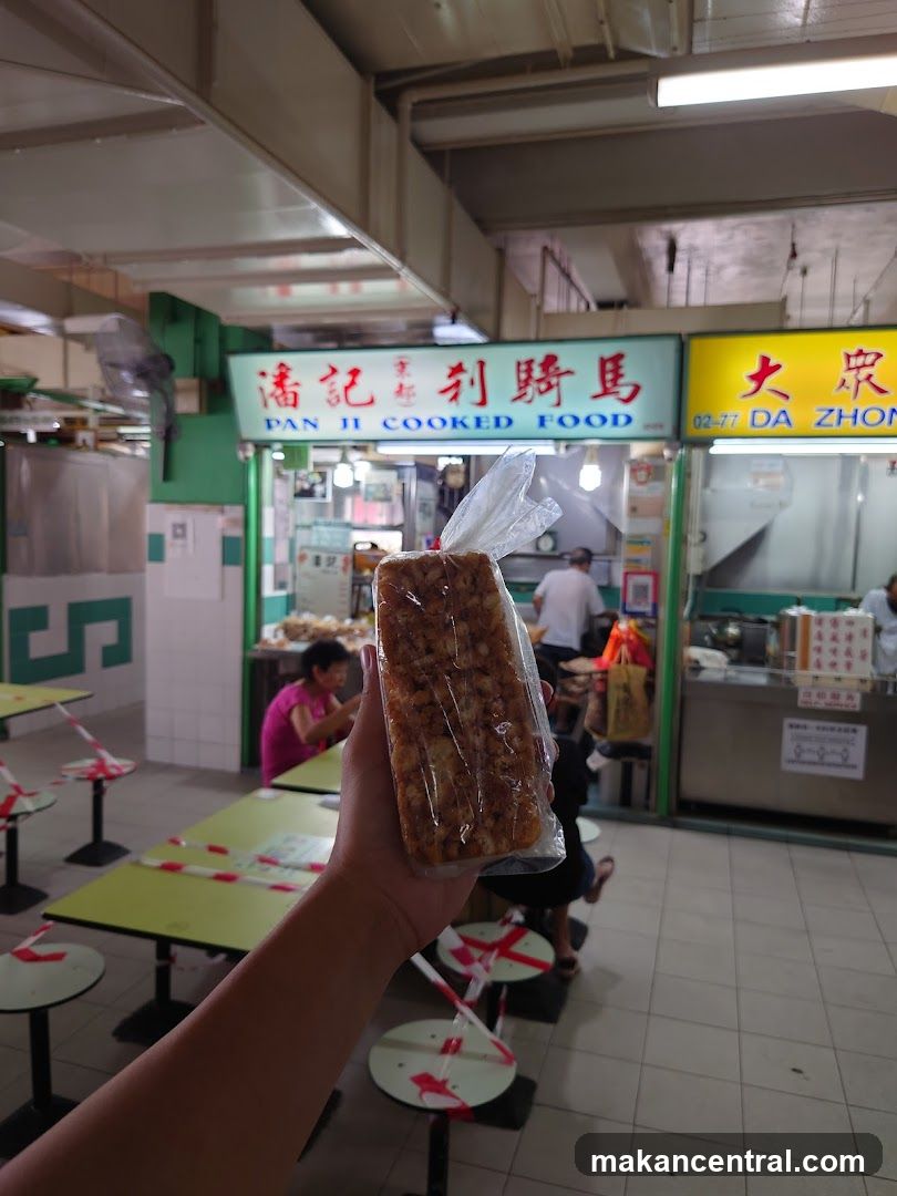 Person holding a packaged food item in a food court