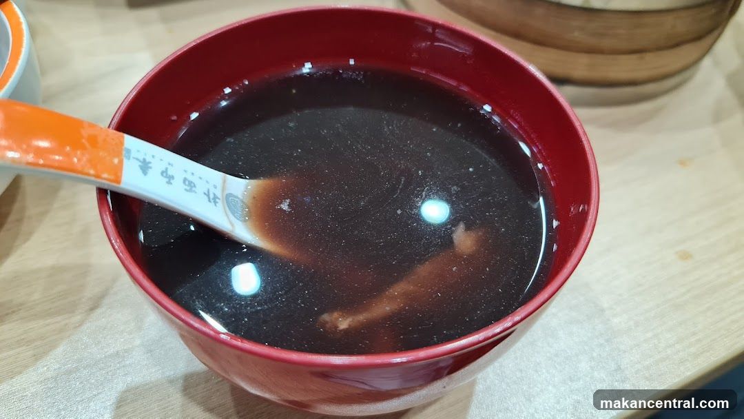 Bowl of Dark Soup with Spoon