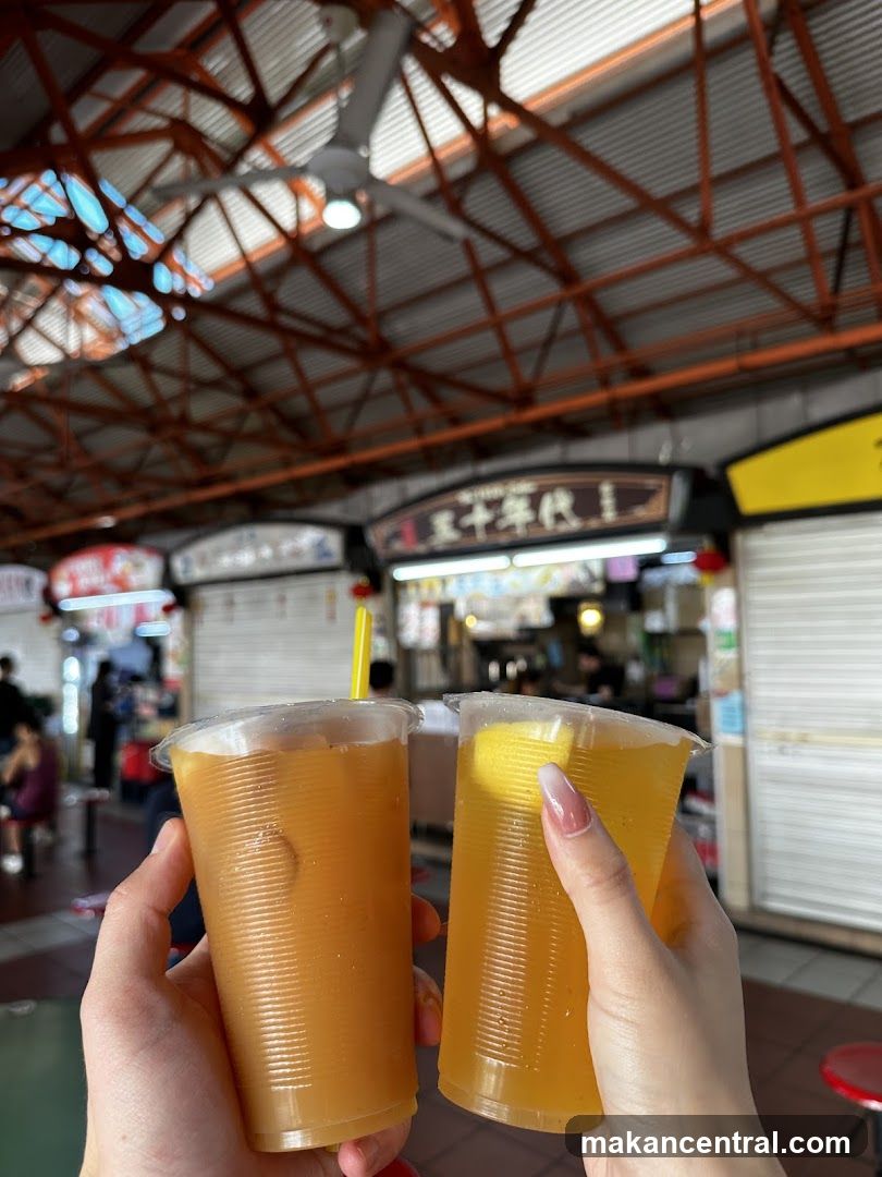 Two drinks held up in front of food stalls