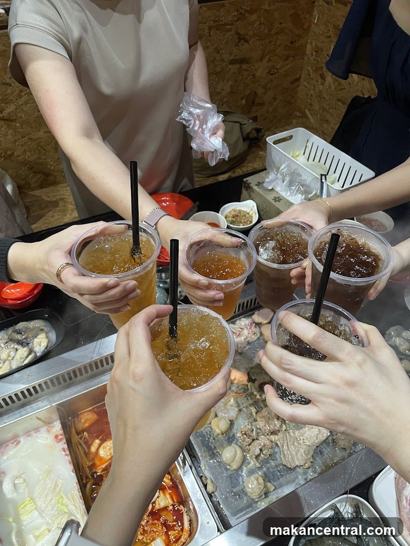 Friends toasting with drinks over a hot pot