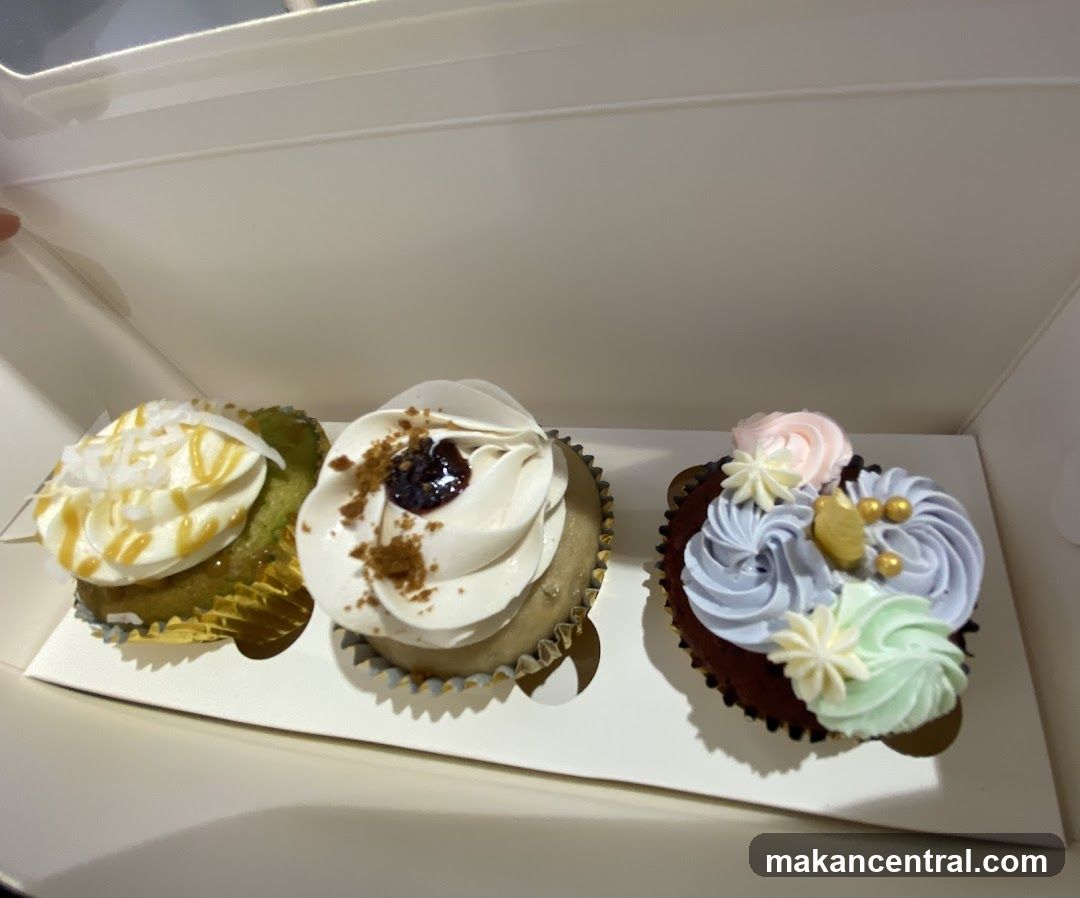 Three decorated cupcakes in a box