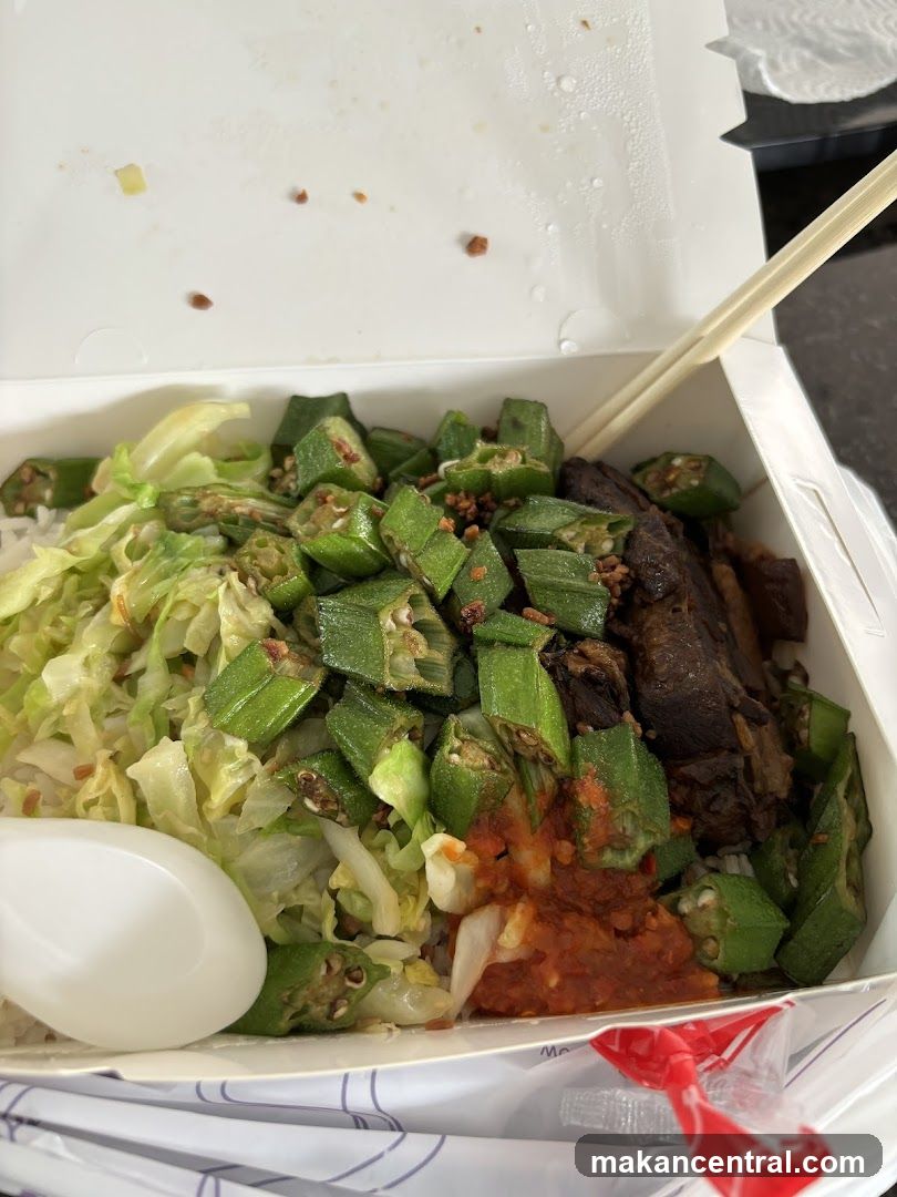 Takeaway meal with rice, meat, okra, and cabbage