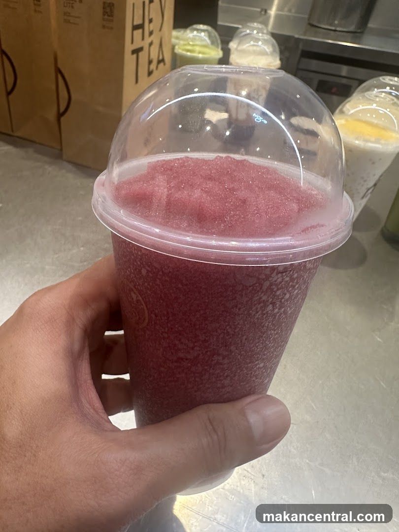 Hand holding a pink slushy drink