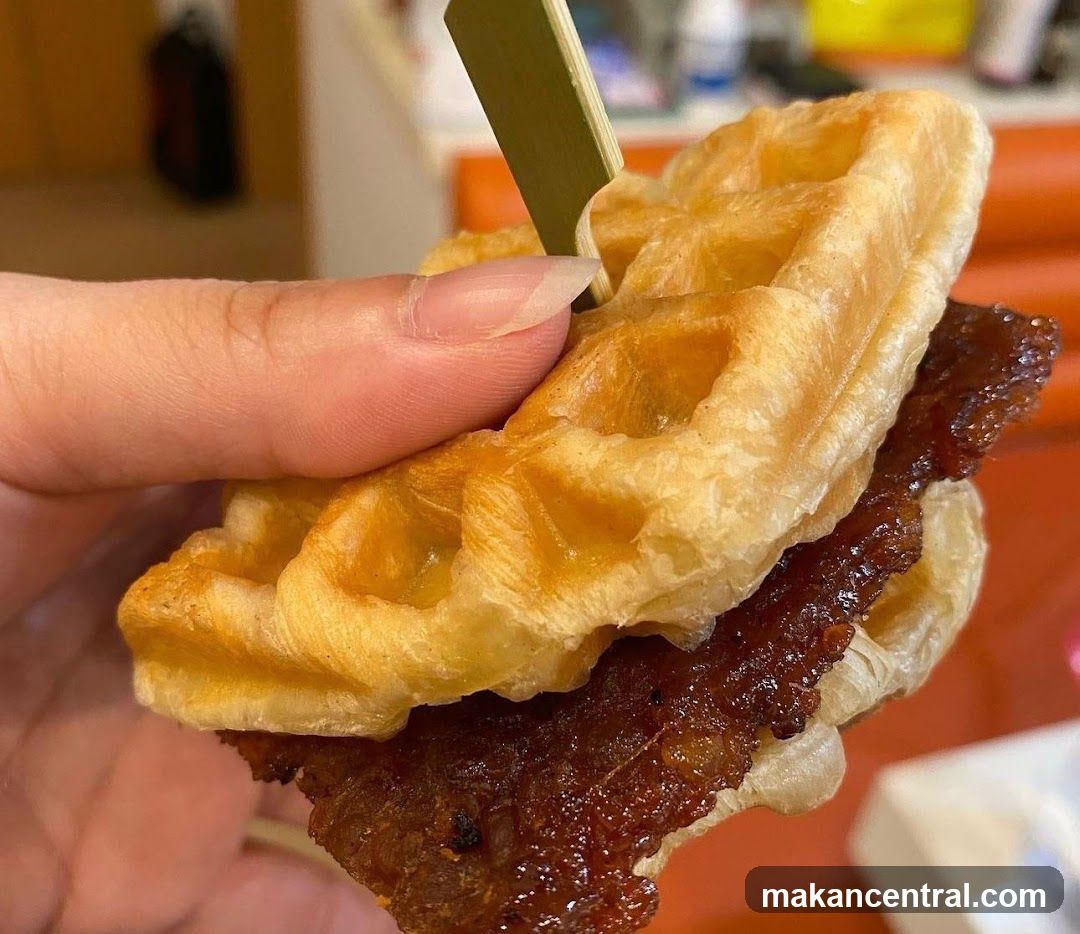 Hand holding waffle sandwich