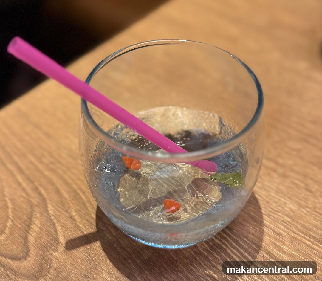 Glass with drink and straw on wooden table