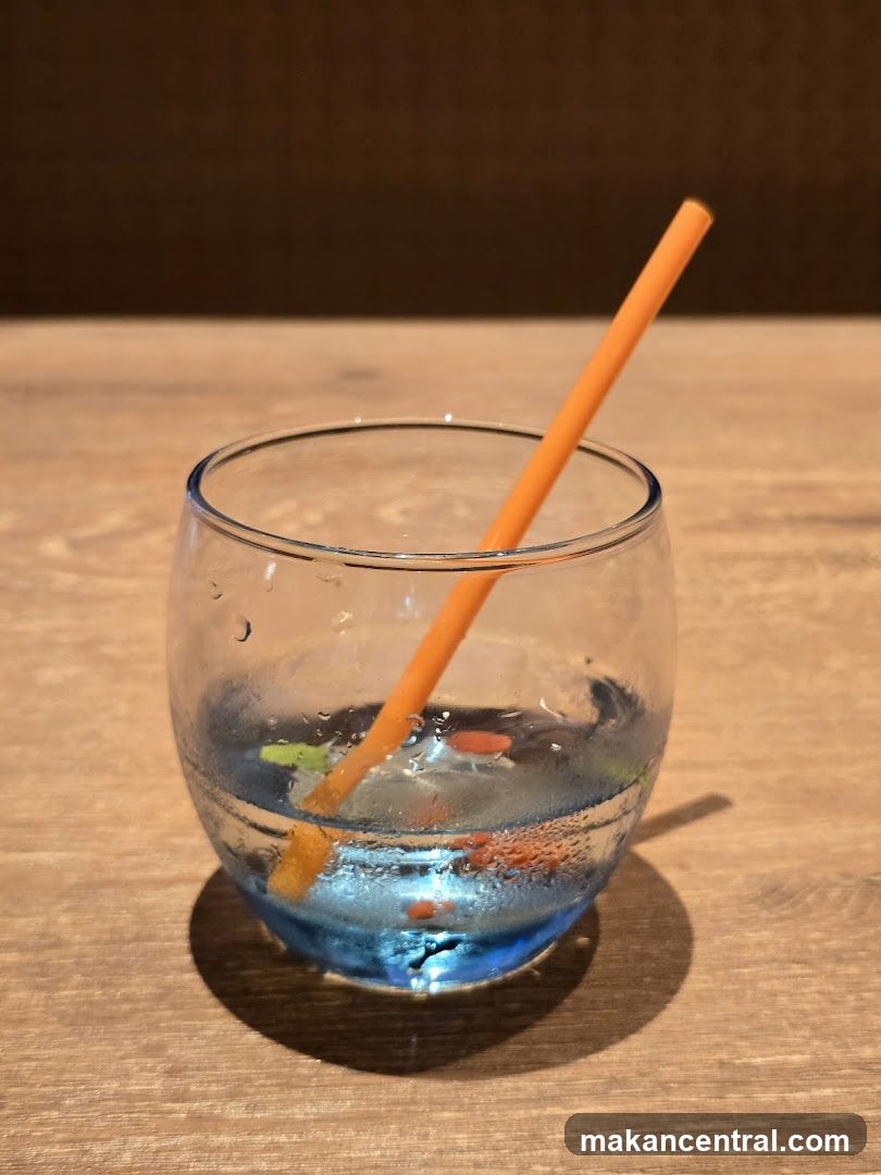 Glass with beverage and straw on wooden surface