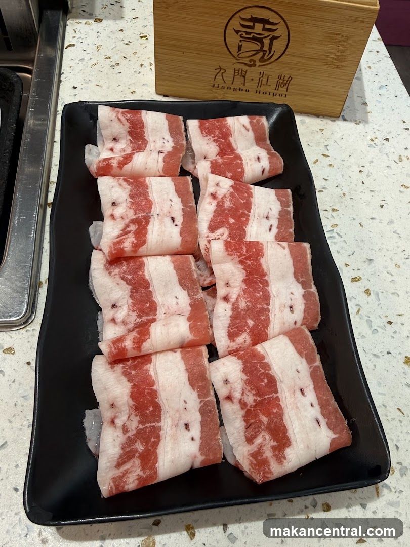 Raw meat slices on black plate