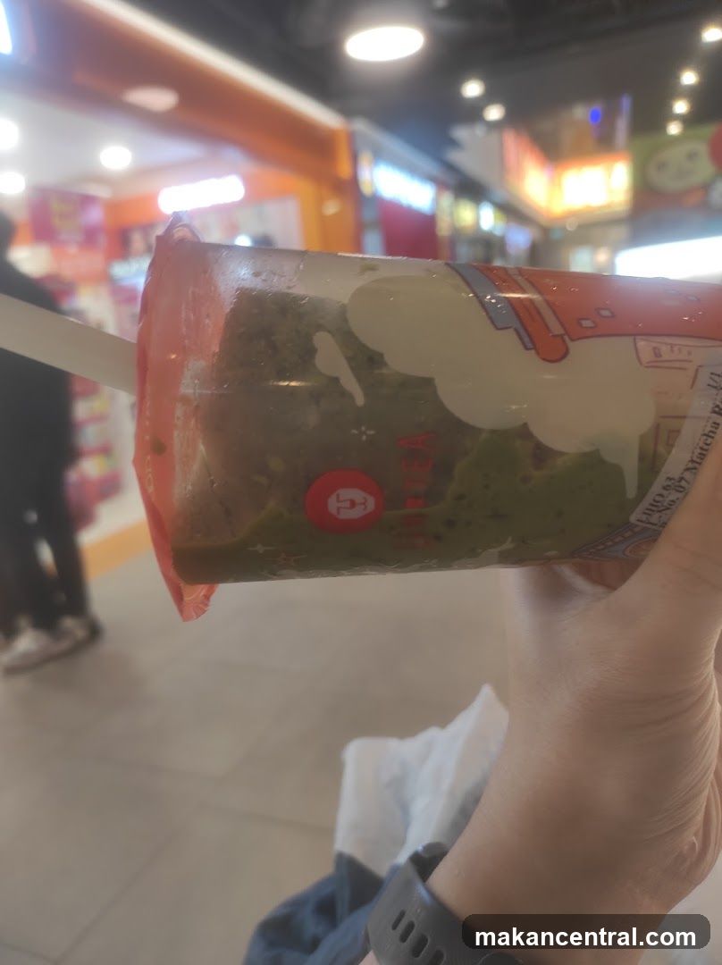 Hand holding matcha tea drink