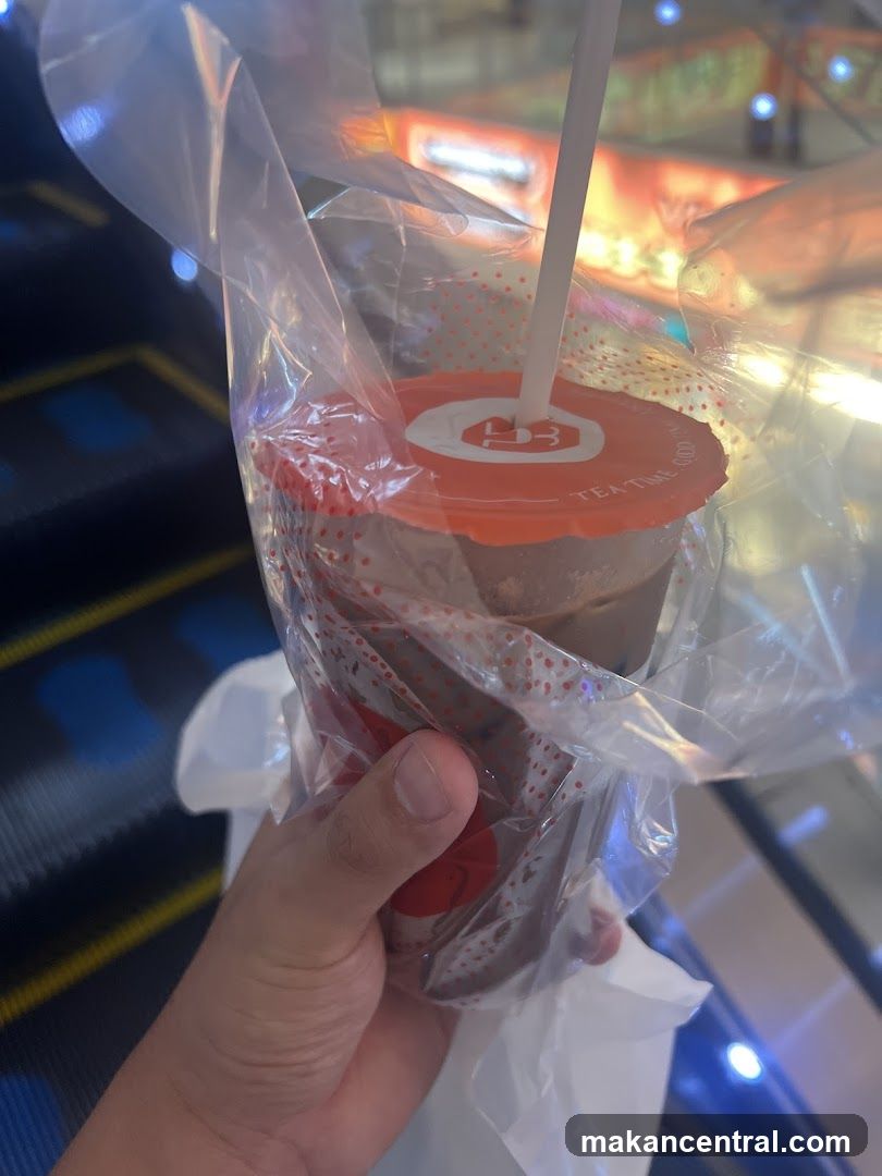 Hand holding a wrapped beverage cup