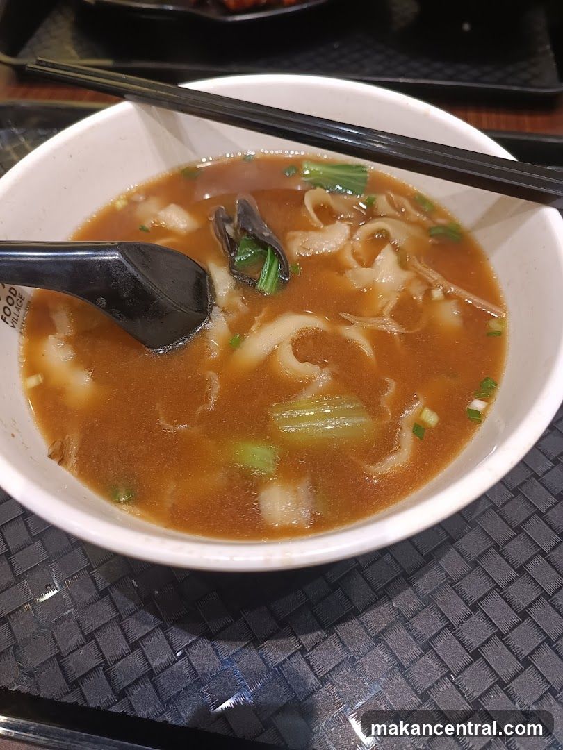 Bowl of soup with chopsticks and spoon