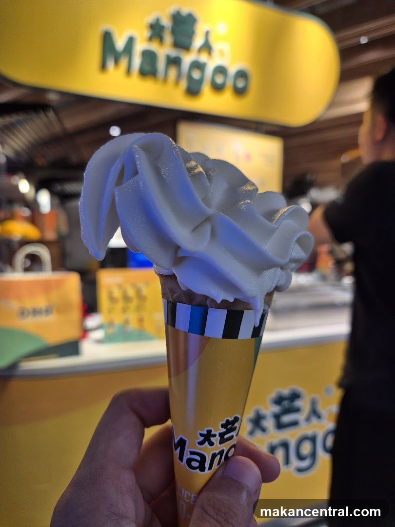 Mango ice cream cone held in hand