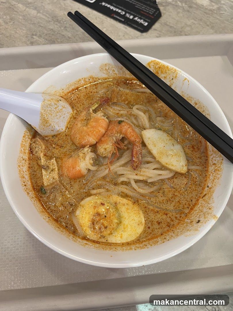 Laksa bowl with chopsticks and spoon