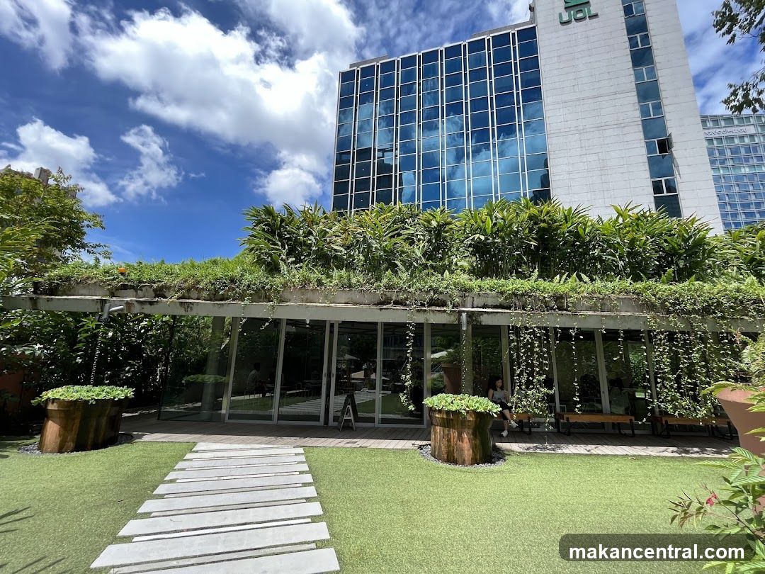 Outdoor seating area with greenery and modern building backdrop