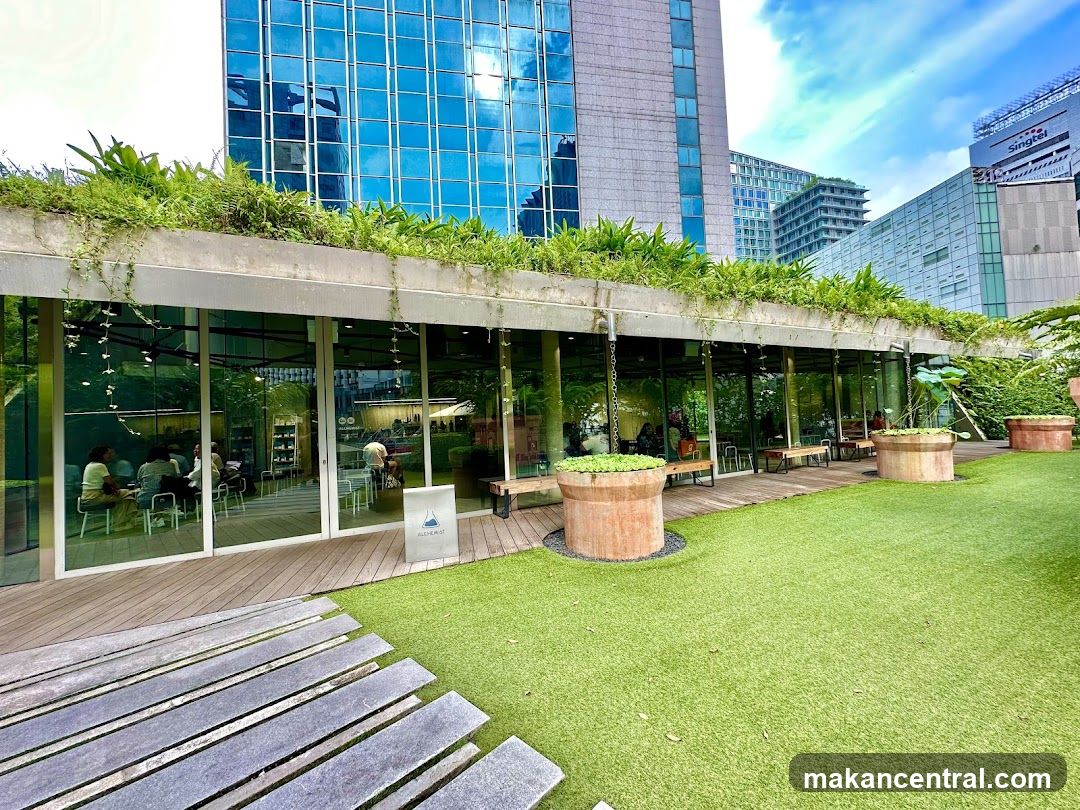 Outdoor seating area with greenery and glass storefront