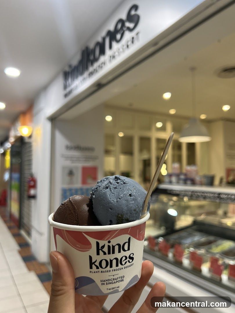 Handheld ice cream cup in front of Kind Kones storefront