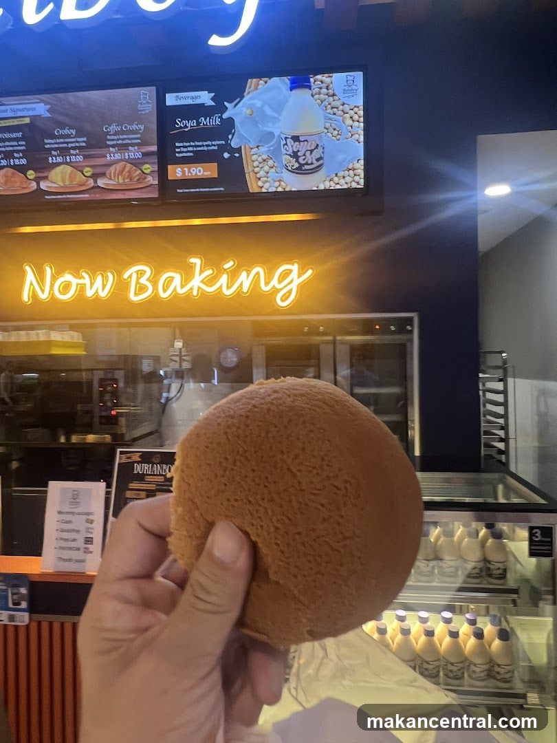 Hand holding pastry in front of bakery counter