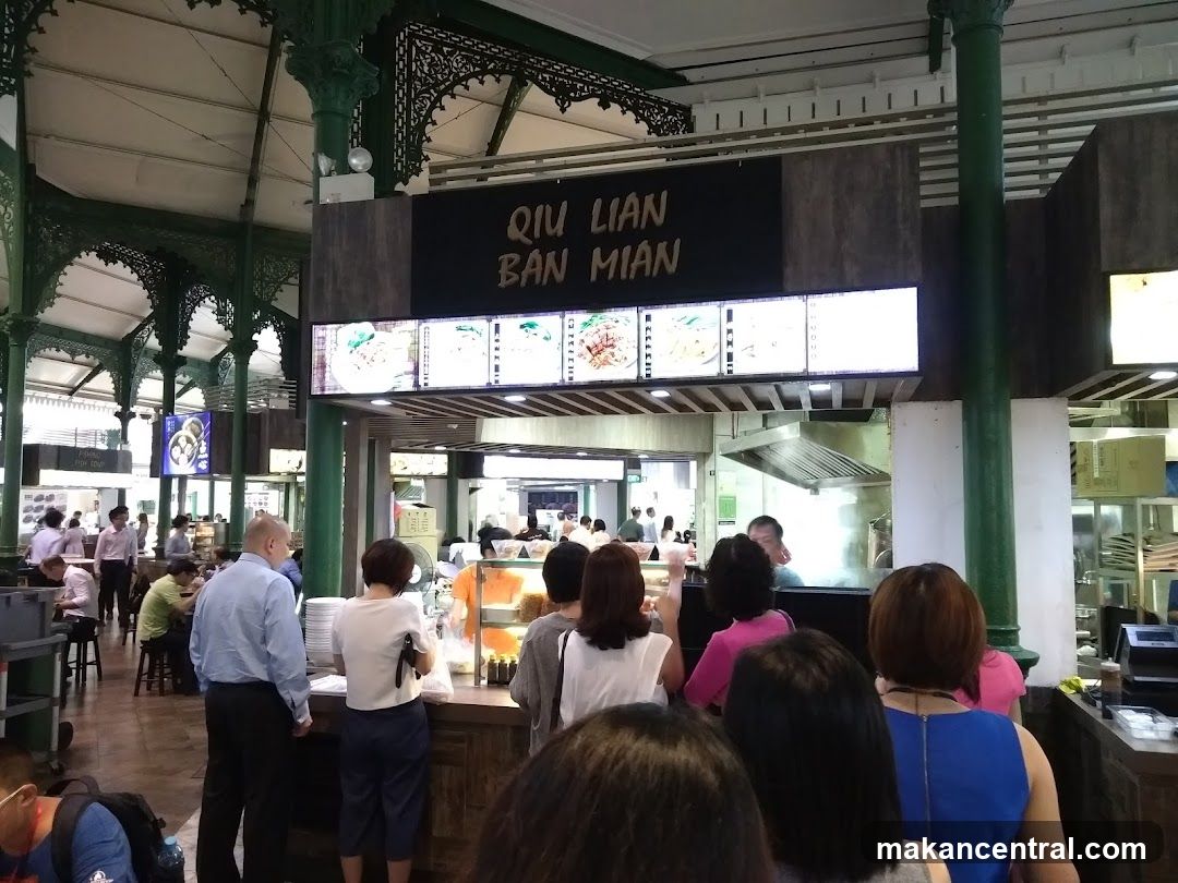 Interior of a food court with customers at a noodle stall