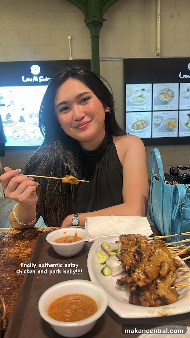 Woman enjoying satay at restaurant