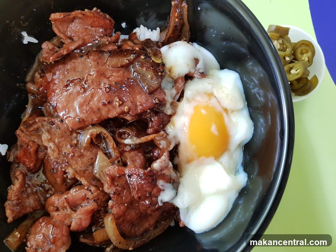 Bowl of meat and egg rice with side of pickled jalapeños