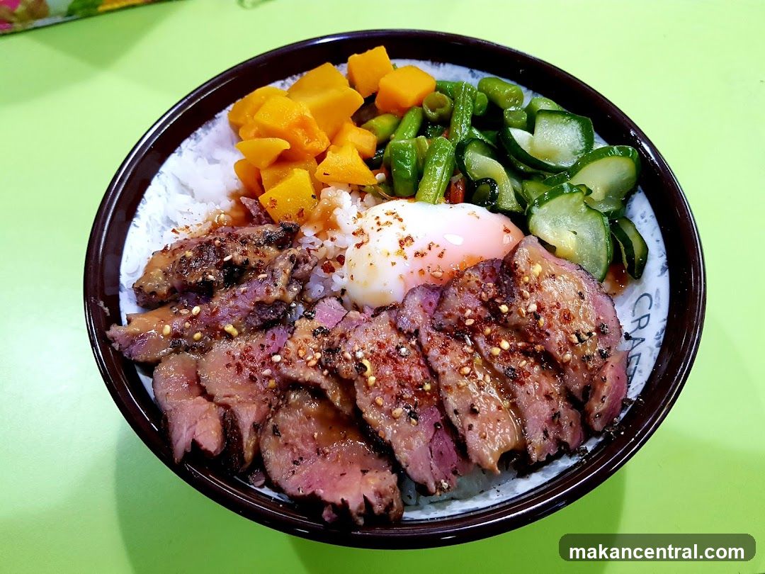 Bowl of rice with meat, vegetables, and egg
