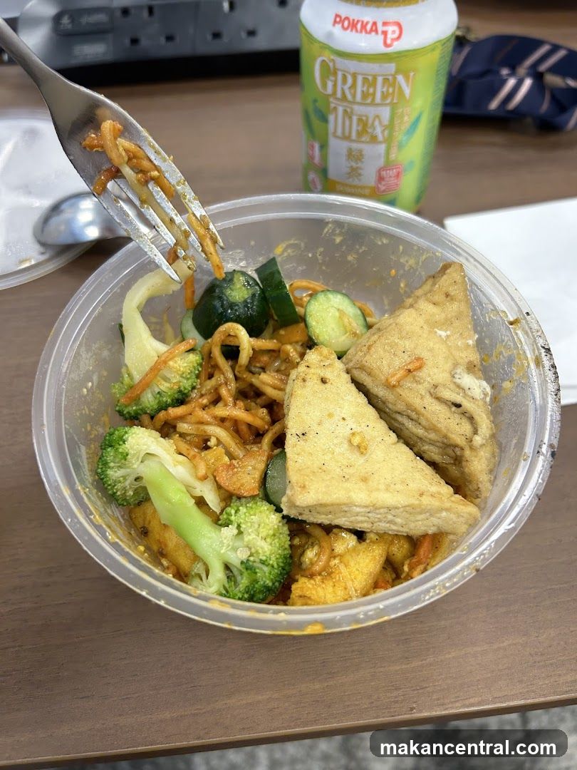 Meal in plastic container with fork and green tea drink