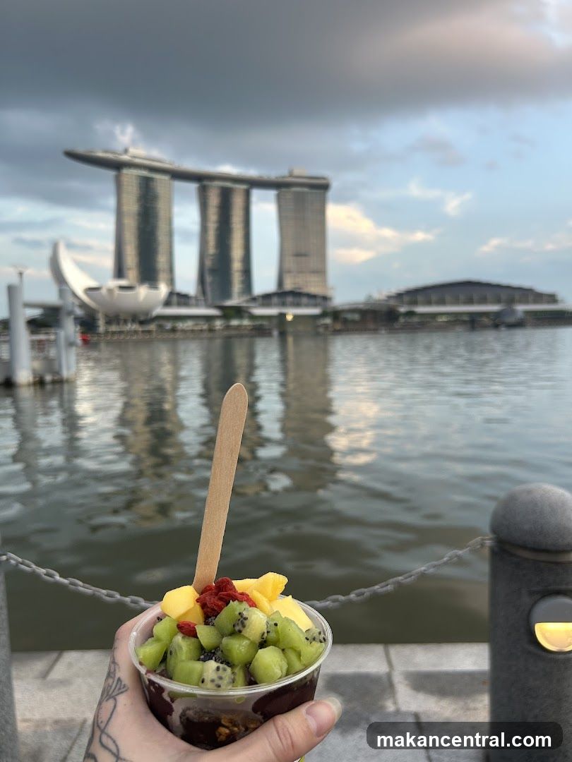 Hand holding fruit dessert with Marina Bay Sands in background