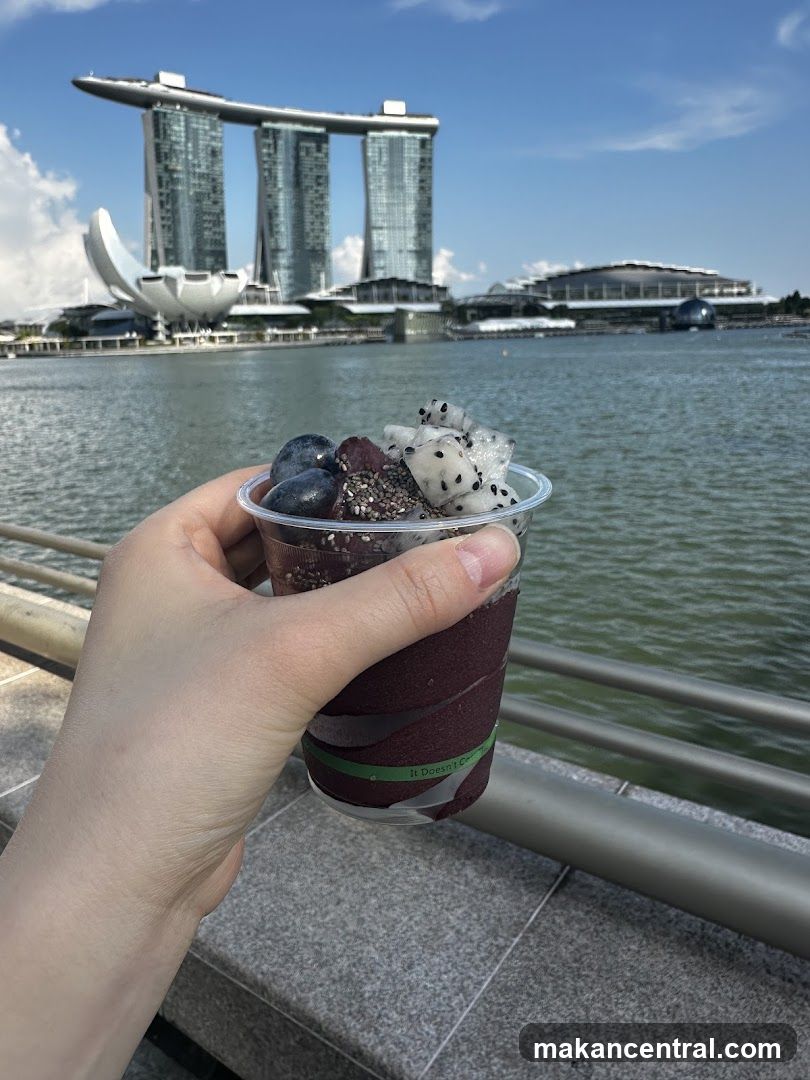 Hand holding fruit cup with Marina Bay Sands in background