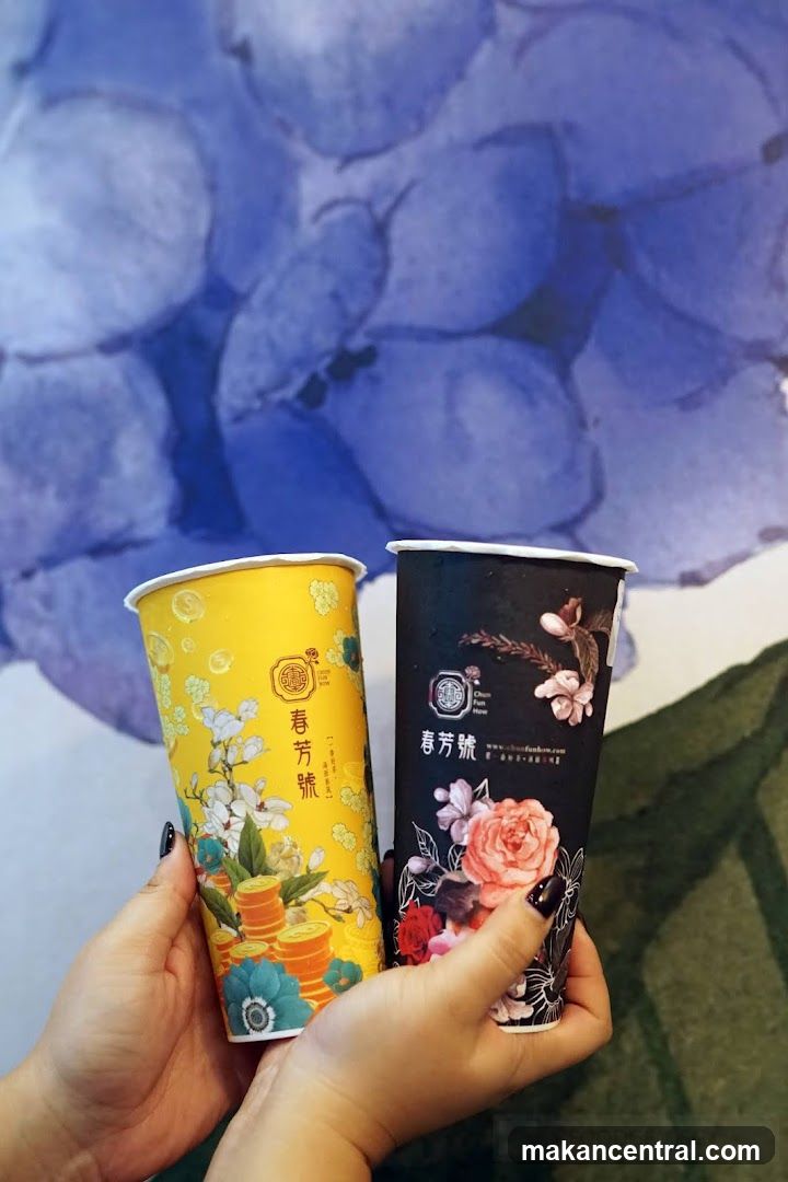 Two branded beverage cups held in hands