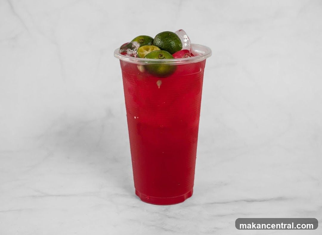 Red beverage with lime garnish