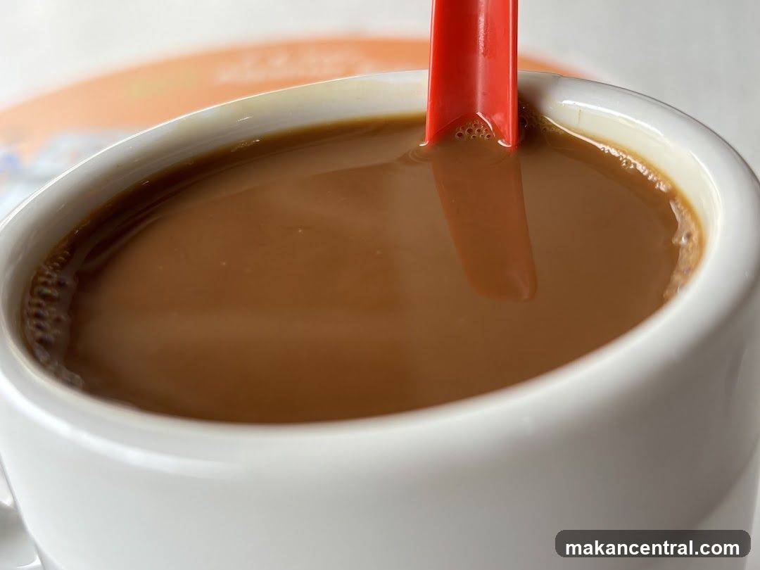 Cup of beverage with red spoon