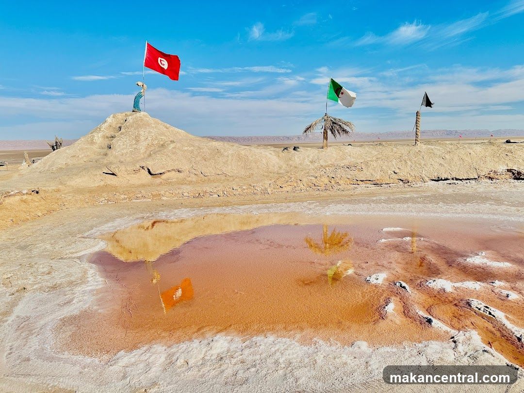 Desert landscape with flags and water pool