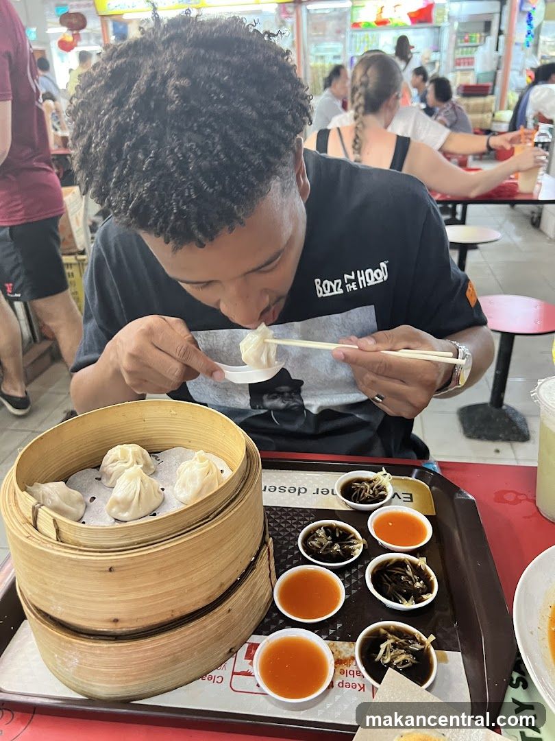 Person eating dumplings at a food stall