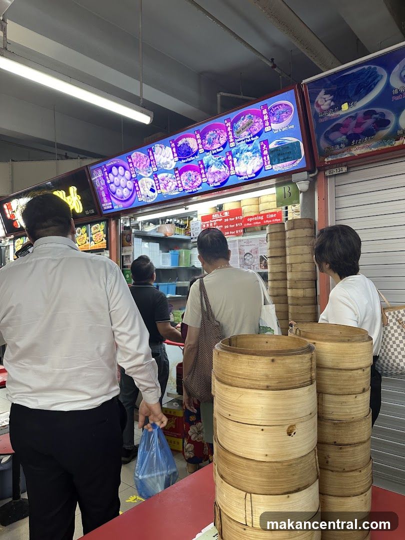 Food stall interior with customers and bamboo steamers
