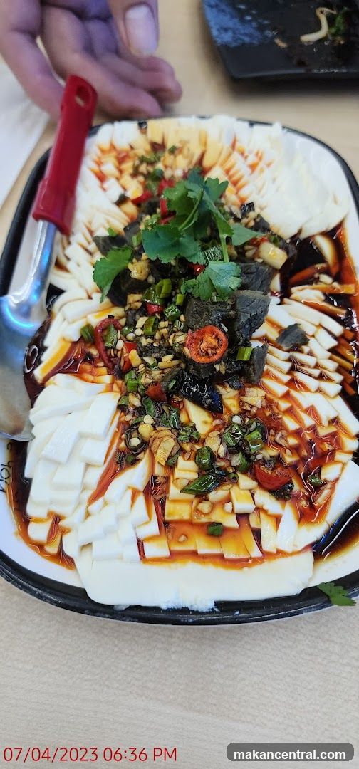 Dish of sliced tofu with chili oil and garnishes