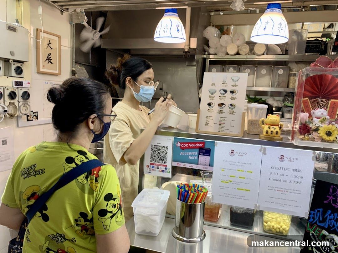 Food stall interior with staff and customer