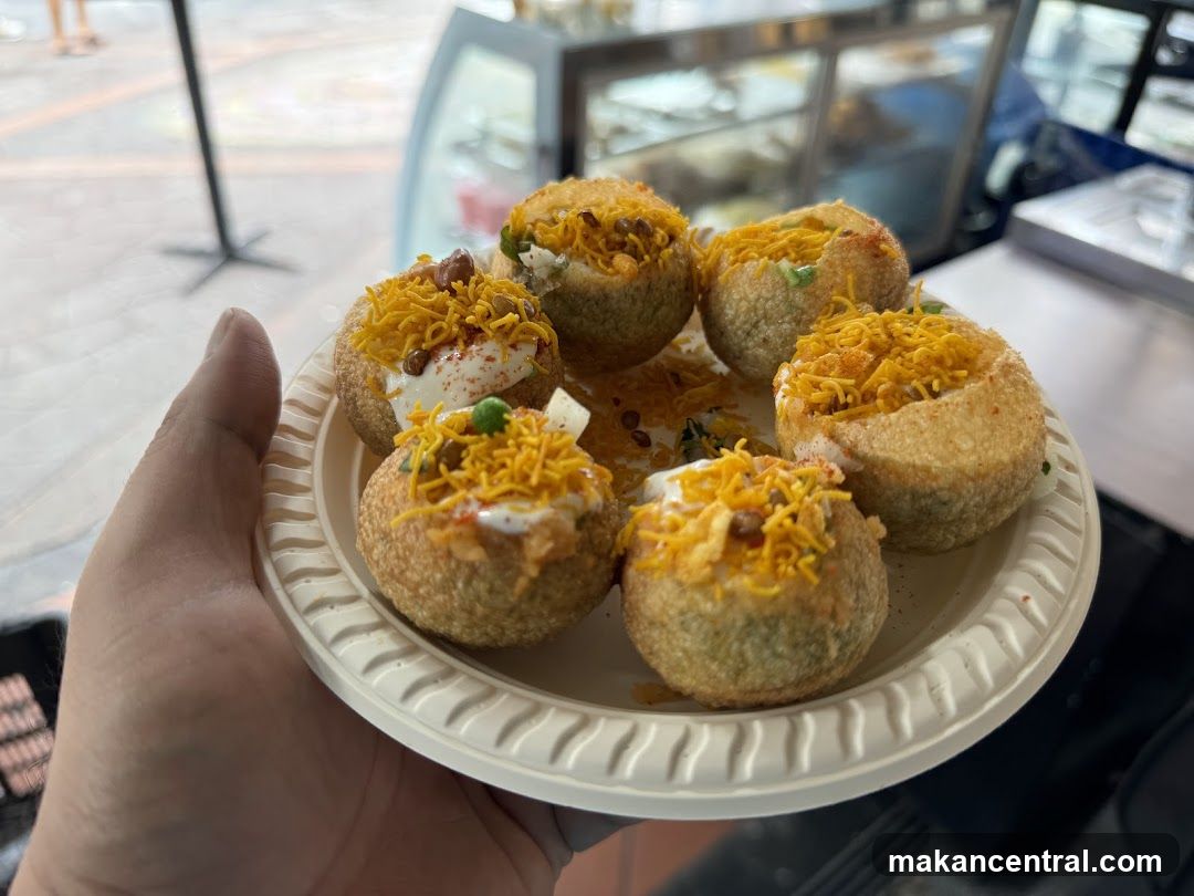 Hand holding plate of pani puri