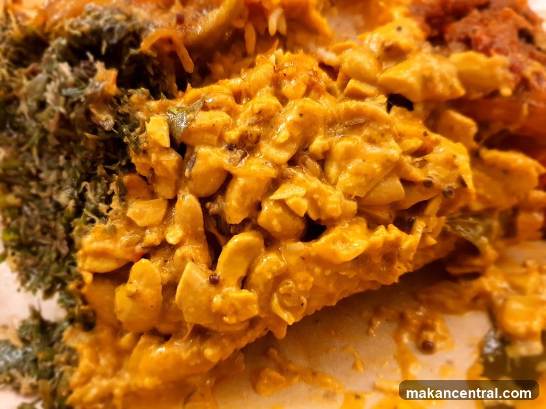 Close-up of a creamy curry dish with rice and greens.