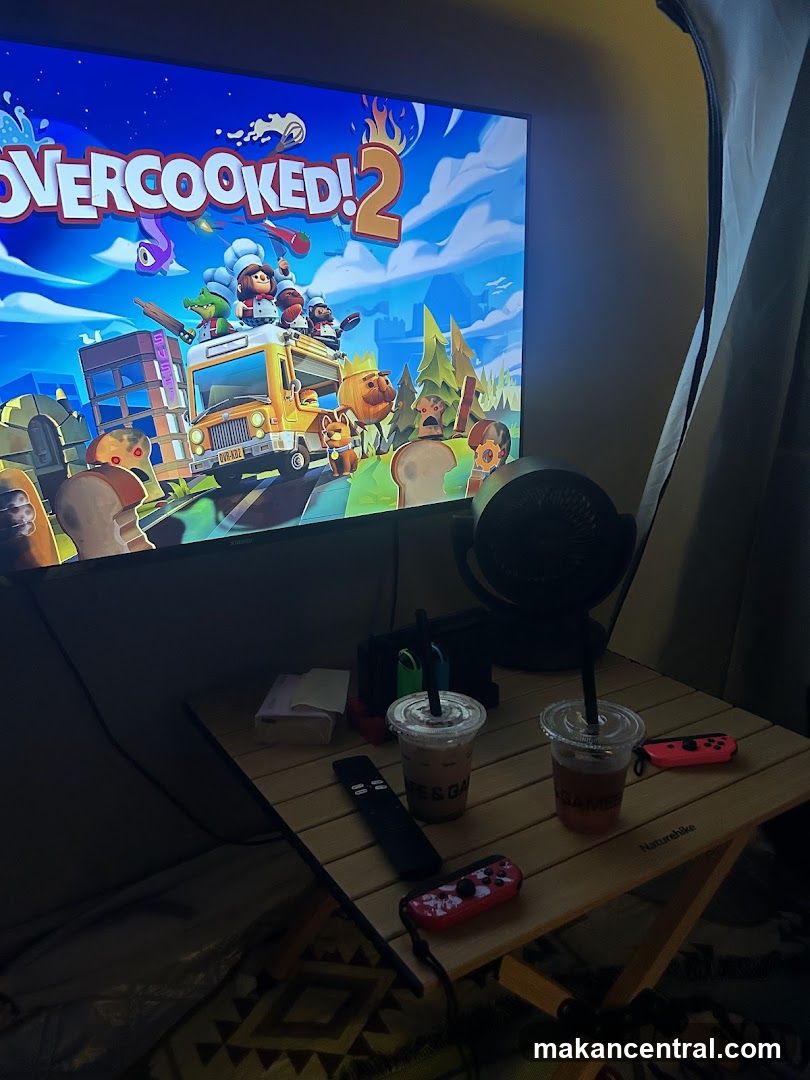 Overcooked! 2 gameplay on TV with drinks and game controllers
