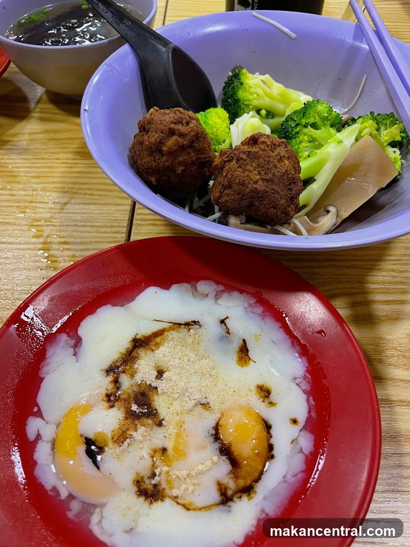 Soft-boiled eggs with soy sauce and a bowl of noodles with broccoli and meatballs