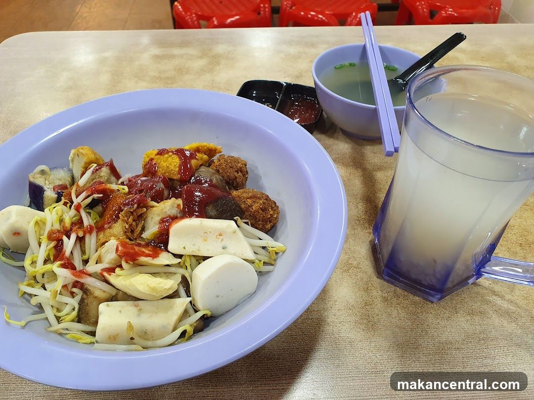 Bowl of noodles with various toppings and a drink