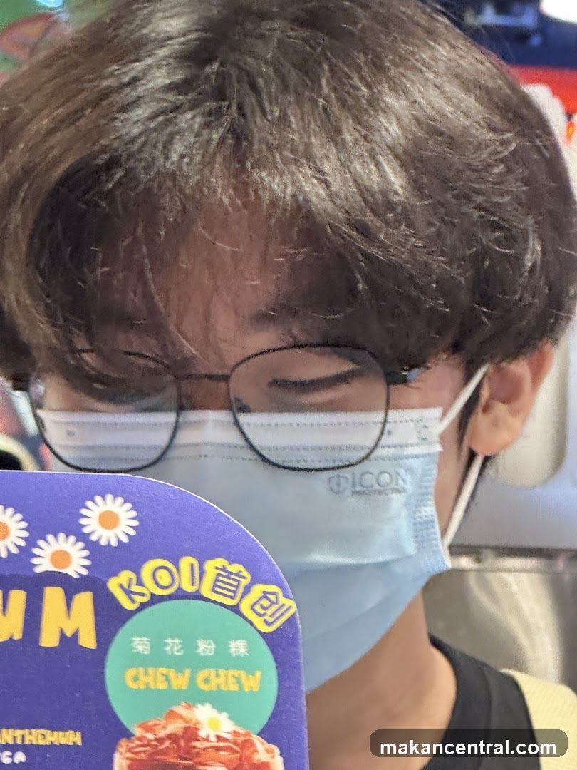 Person wearing a mask and glasses holding a menu item